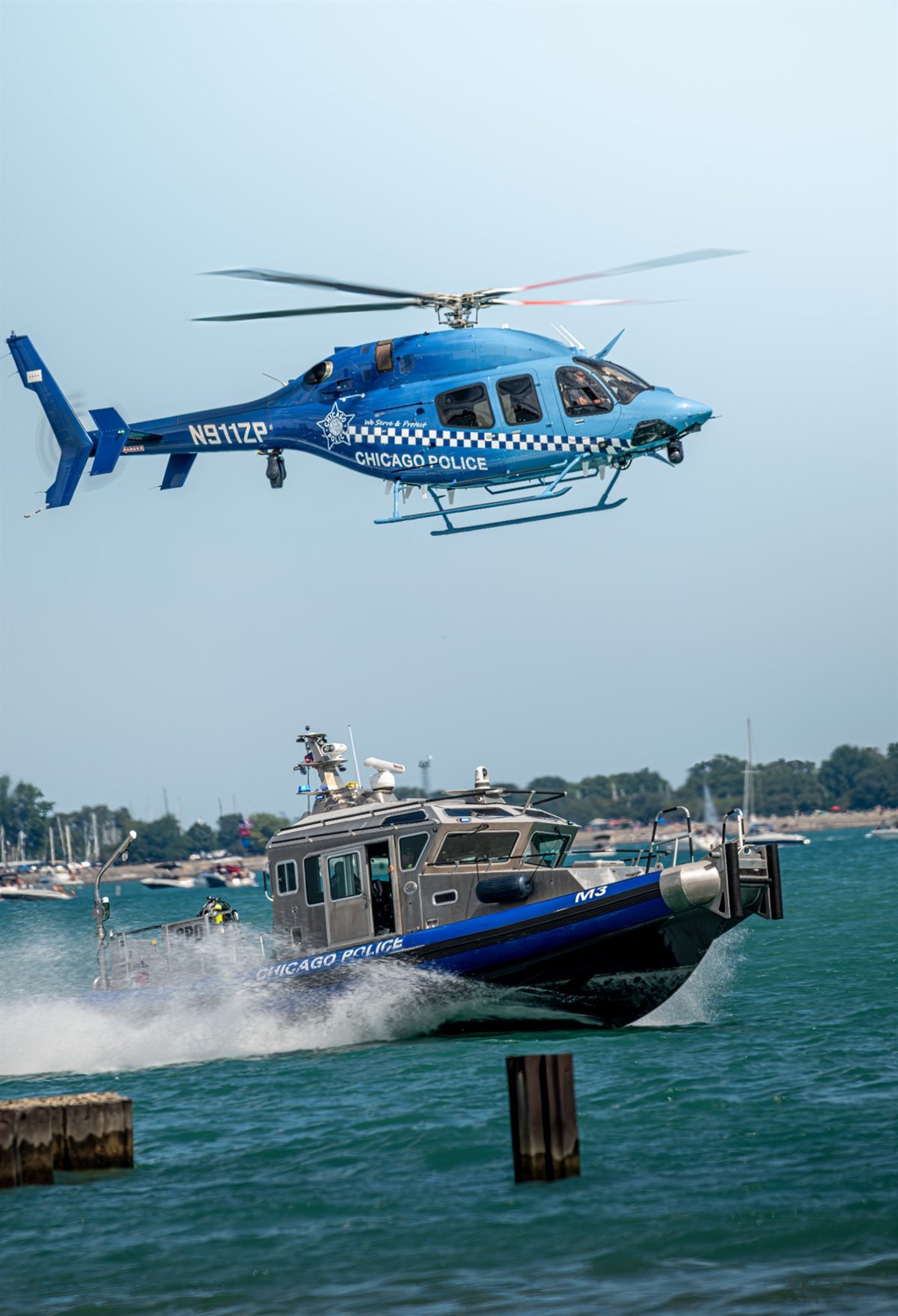 A Chicago Police Bell 429 helicopter working above a Chicago Police marine unit boat on Lake Michigan